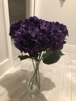Fake purple flowers in glass vase