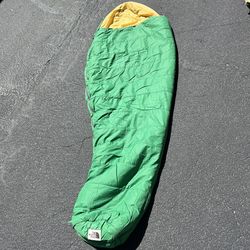 vintage The North Face mummy sleeping bag with a green shell and yellow liner