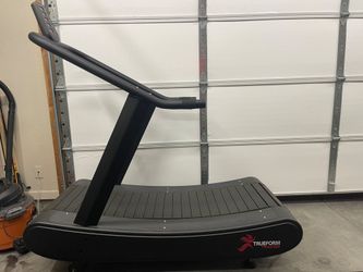 TrueForm Trainer non-motorized curved treadmill with a slatted running belt.