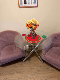 Round dining table with glass top in pair of purple chairs