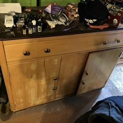 vintage wooden cabinet or dresser with a dark top surface.