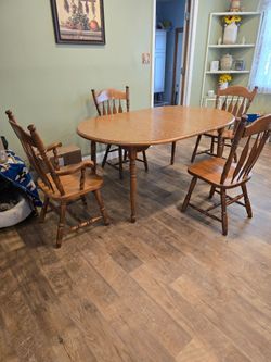 Solid oak diningroom table set with 4 chairs, 2 matching hutches, and buffet table
