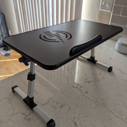 Laptop lap desk with adjustable angle, foldable leg, and working fan.