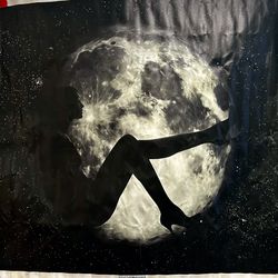 woman against a large, bright full moon and a starry sky.