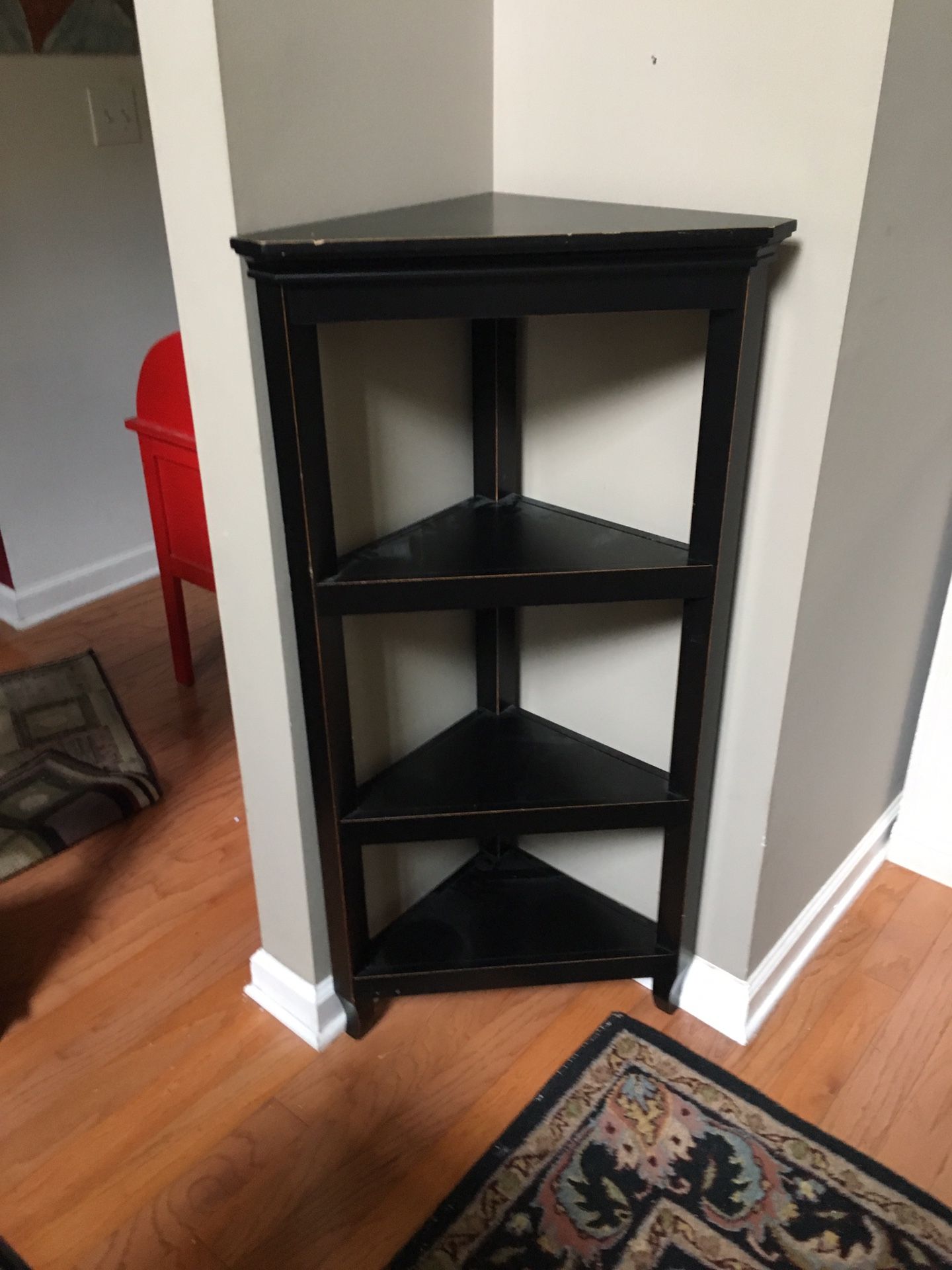 Three shelf black wooden corner cabinet