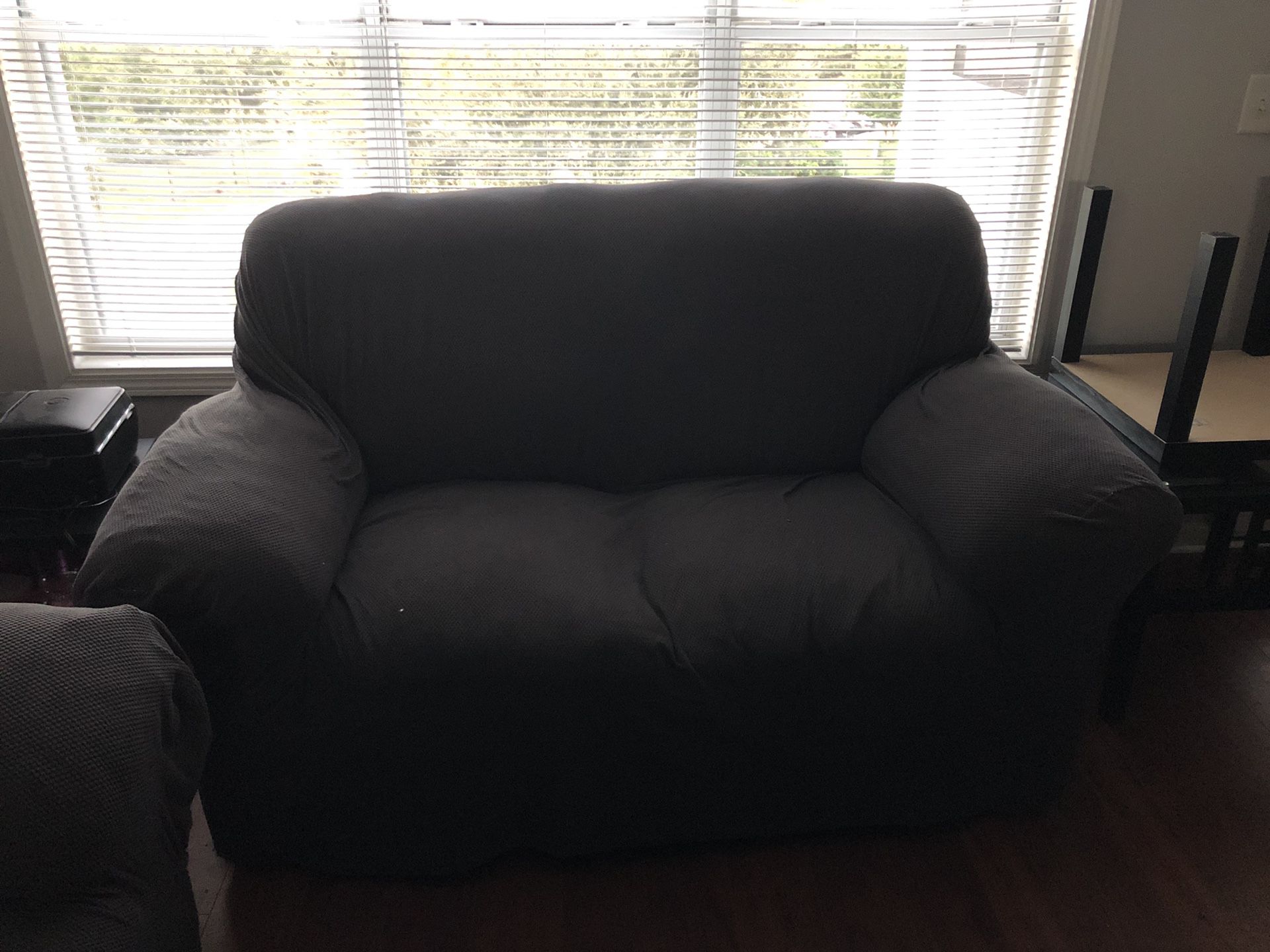 Two brown leather couches with gray couch covers