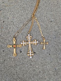 vintage-inspired, gold-tone layered cross necklaces featuring imitation pearls and rhinestone accents.