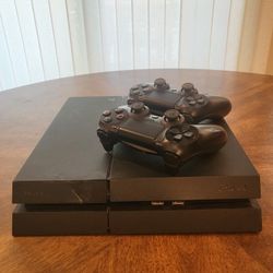 Playstation 4 with 2 controllers, power cord, controller charging cord, and controller charging dock.