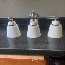 Three light polish chrome bathroom vanity, light fixture with white glass shades