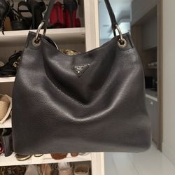 This is a black Prada Vitello Daino pebbled leather hobo bag with silver-tone hardware. 
