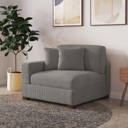 Upholstered light gray corduroy armchair with pillow back and solid wood legs 
