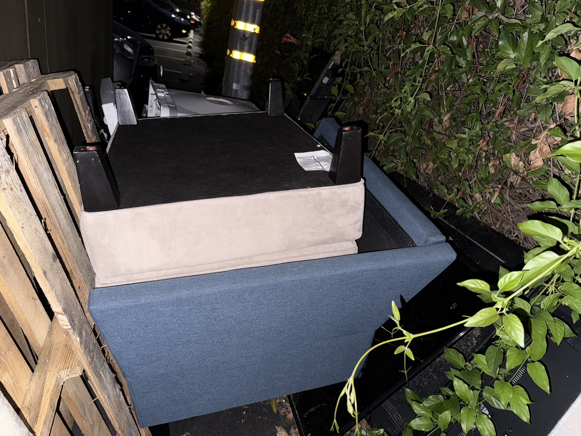 Blue upholstered chair w/o cushions and beige upholstered ottoman.