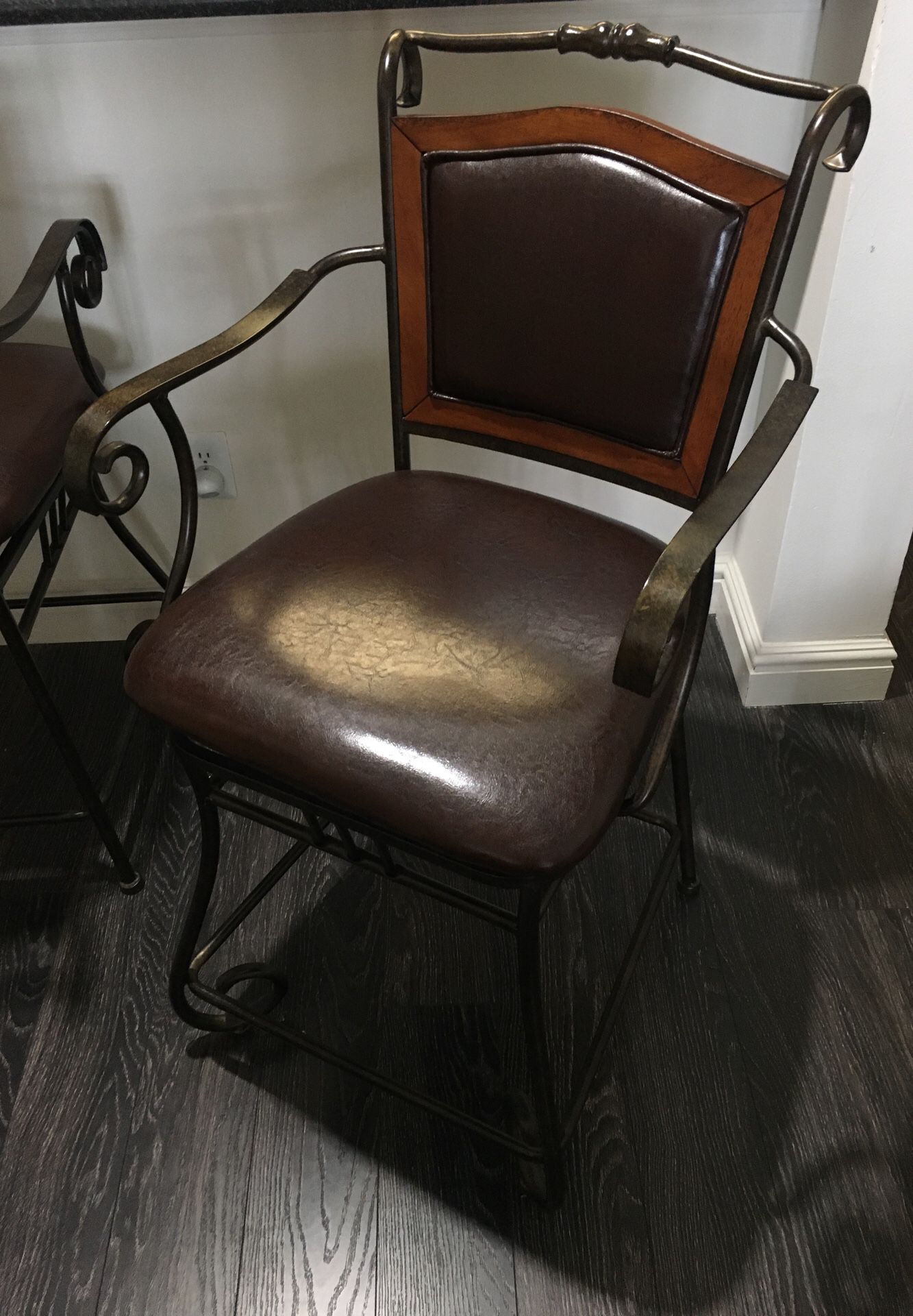 Two counter-height chairs. Brown rustic metallic frame and brown leather padding