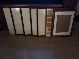 displays a collection of multiple empty picture frames and mats