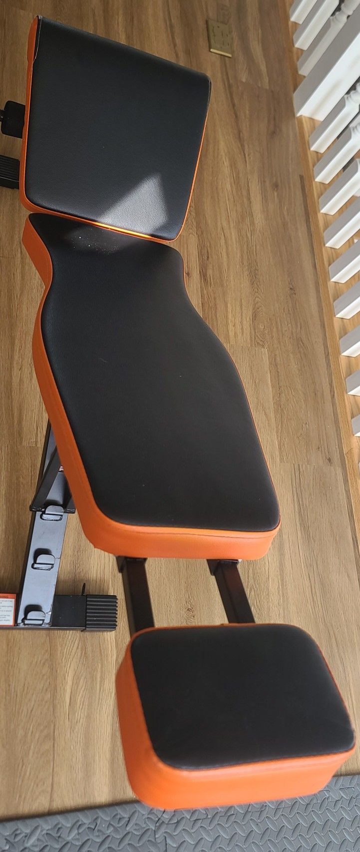 Adjustable weight bench with orange and black padding