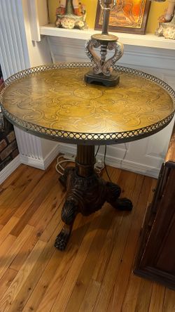 Heavily carved 28” round wooden with leather top table