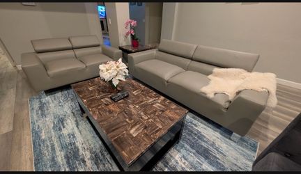 modern light gray leather *Sofa and Love Seat* featuring adjustable headrests and wide armrests