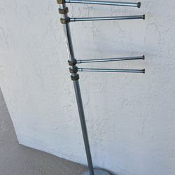 Vintage freestanding metal towel stand with four pivoting swing arms. 