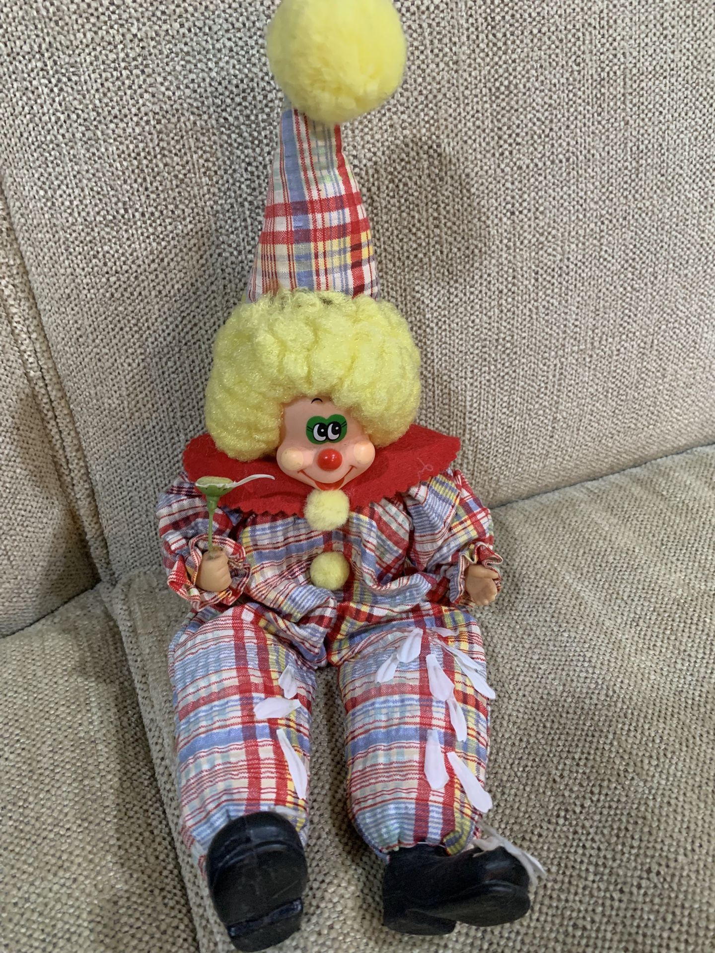 Vintage wind-up musical clown doll with plaid clothing and yellow hair.