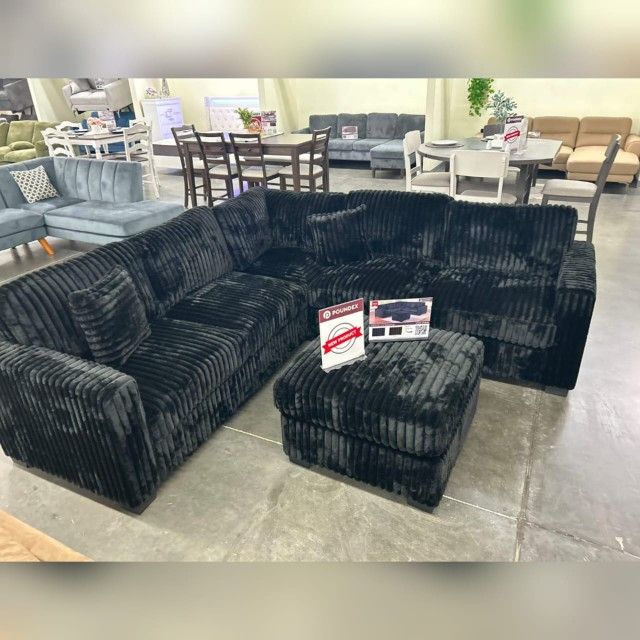 Black jumbo corduroy sectional sofa with ottoman