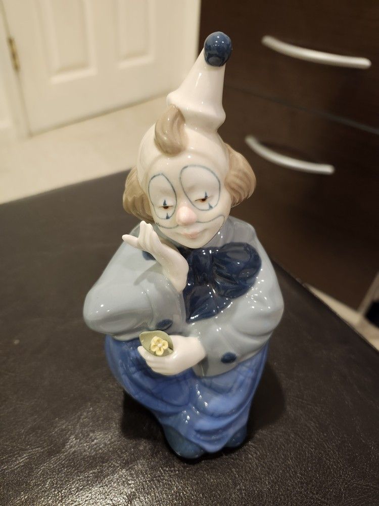 PAUL SEBASTIAN PORCELAIN SEATED CLOWN FIGURINE HOLDING A YELLOW FLOWER