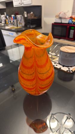 A hand-blown art glass vase with orange and red swirls. Murano