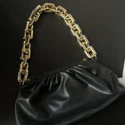 Black handbag with a gold link handle