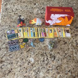 50 Randon Pokémon Cards 5 Pokémon Coins 3 Pokémon Pins 2 GX  Slabs 2 Pokémon Toys 1 Pokémon Box 1 Pokémon Bag Of Dice