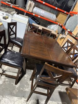 Extendable dining table set with 8 chairs. Used condition with some wear, but still sturdy and functional. Perfect for a large family or extra guests.