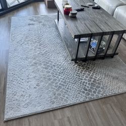 Gray Wood Grain Coffee Table With Casters And Area Rug