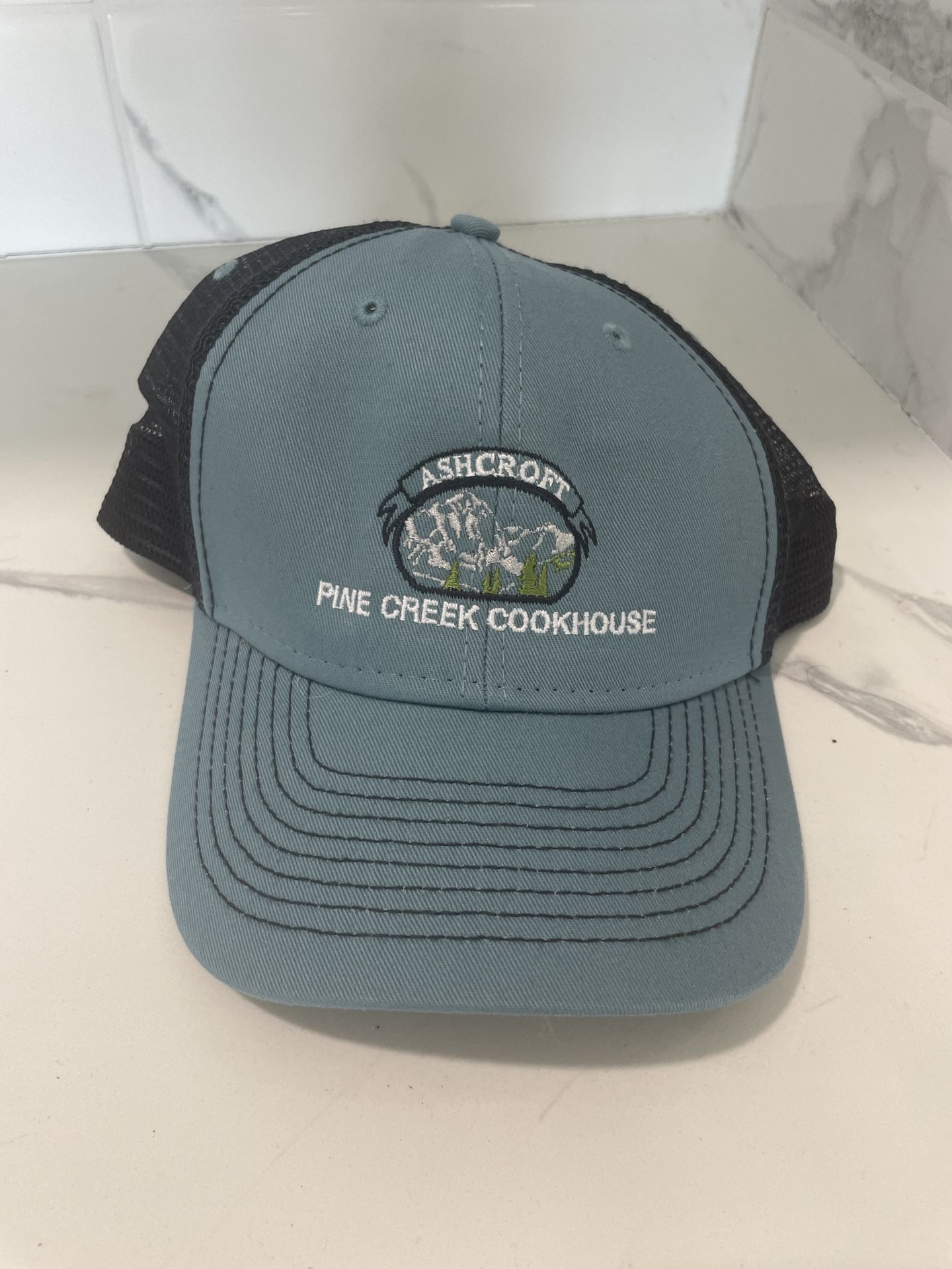 Ashcroft Pine Creek Cookhouse Trucker Hat β Mountain Scene Embroidery