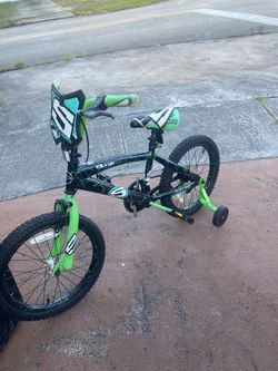 shows an 18-inch Surge Boys Bike in green and black