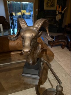 Mid-century brass ram's head desk sculpture featuring large, curved horns mounted on a black pedestal