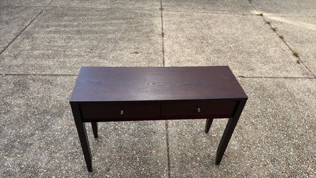 A wooden sofa table with two drawers