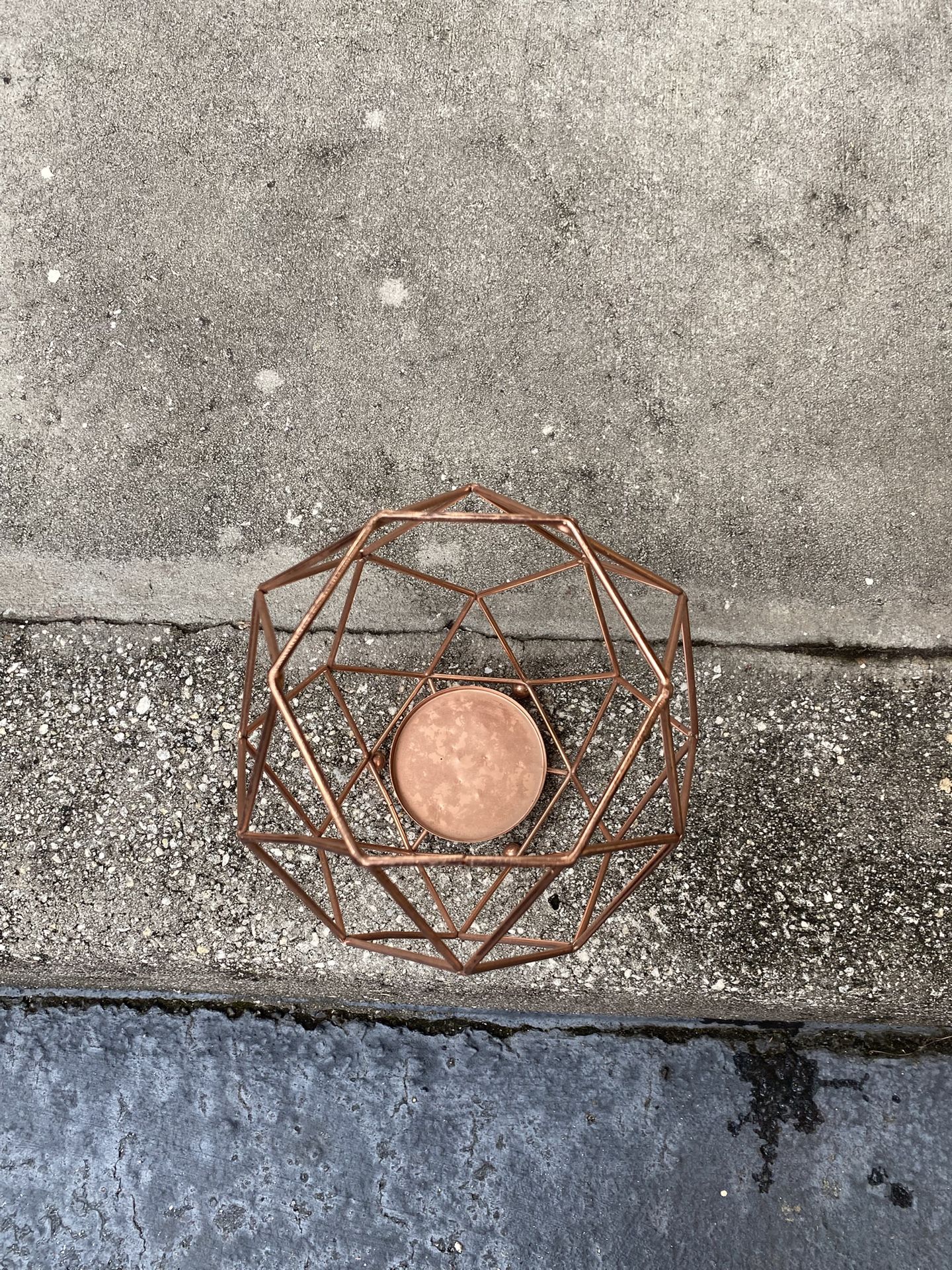 This is a modern geometric copper metal candle holder. 