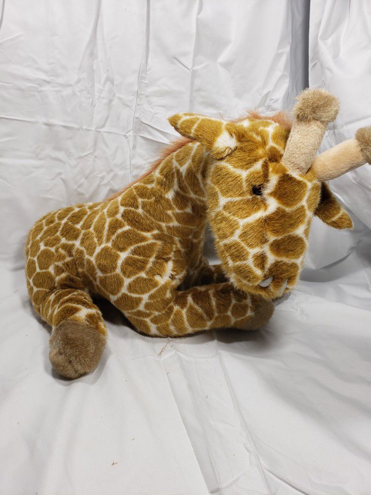Plush Giraffe toy sitting position.  Good condition and smoke free home.  Giraffe measures 15" T X 14" L