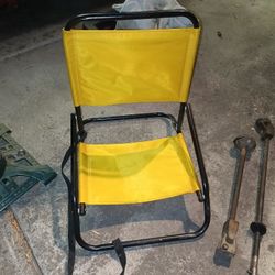 Folding low to the ground camping or beach sand chair with carrying strap