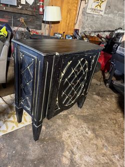 black and gold distressed accent cabinet with geometric fretwork