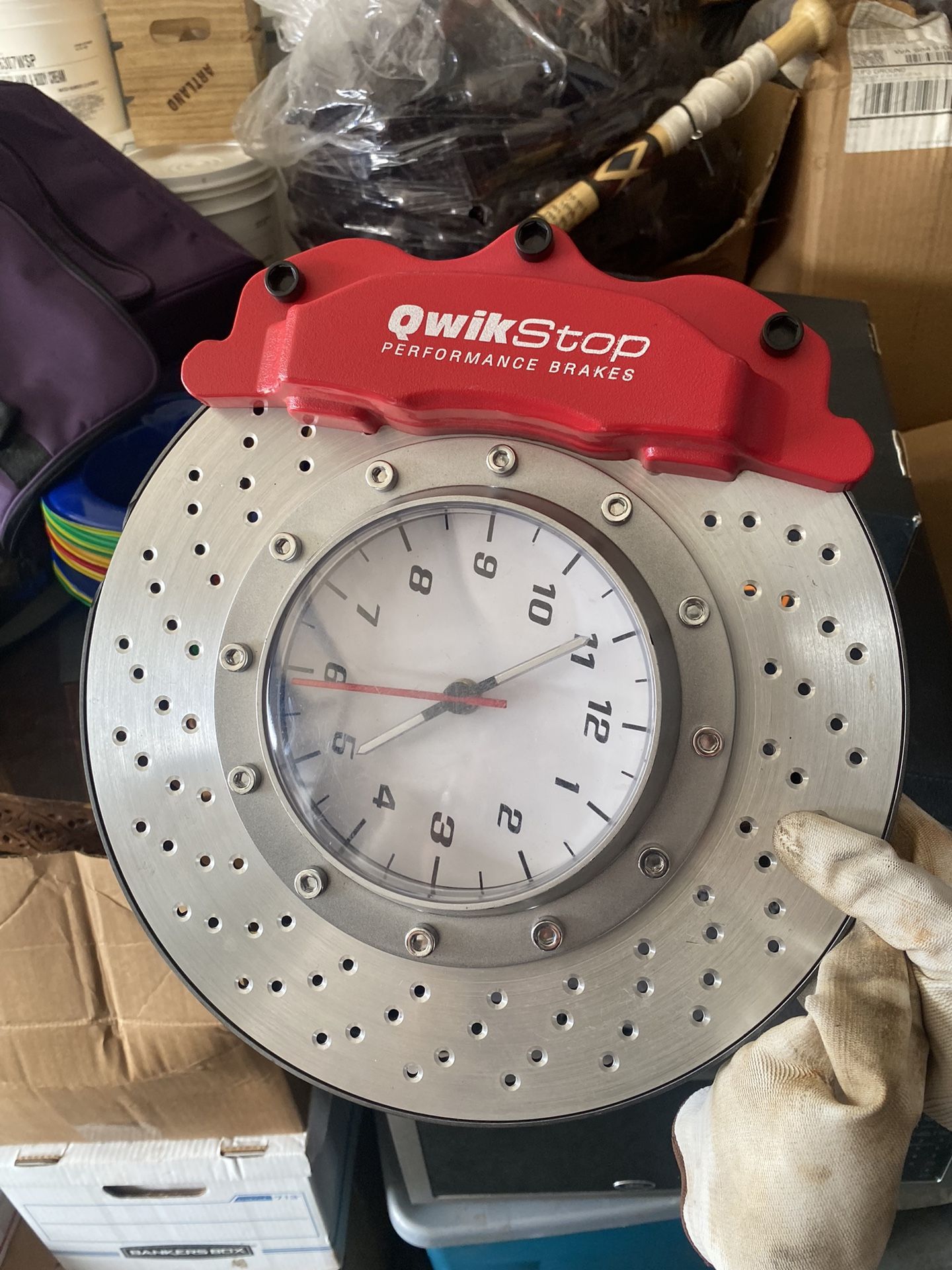 QwikStop Performance Disc Brake Caliper Wall Clock. It's a novelty clock designed to look like a car brake rotor and caliper, often used as decorative