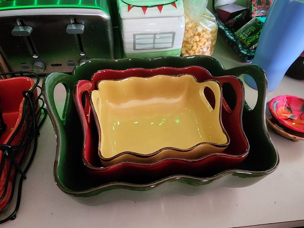 Set of three colorful wimsical Casserol dishes with handles.