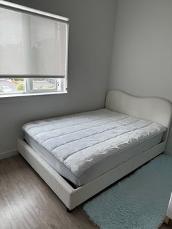 White bouclé upholstered bed, full size, with a spring mattress.