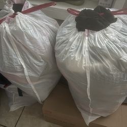 Women Med sweaters and bag full of hangers