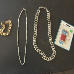 Two chains and a golden bracelet and a bottle opener