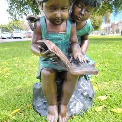 bronze statue sisters children reading a Book 