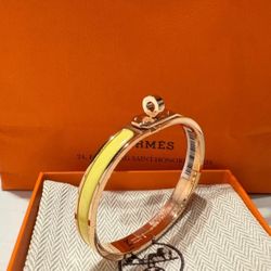 Hermès' new enamel bracelet, made of rose gold with yellow accents.
