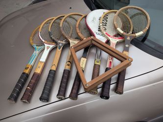 several vintage wooden rackets from brands like Wilson, Rawlings, and Spalding.