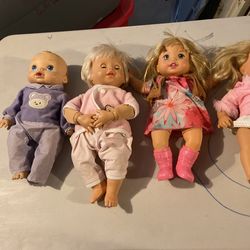 5 Baby Dolls With A Container Full Of Baby Clothes 