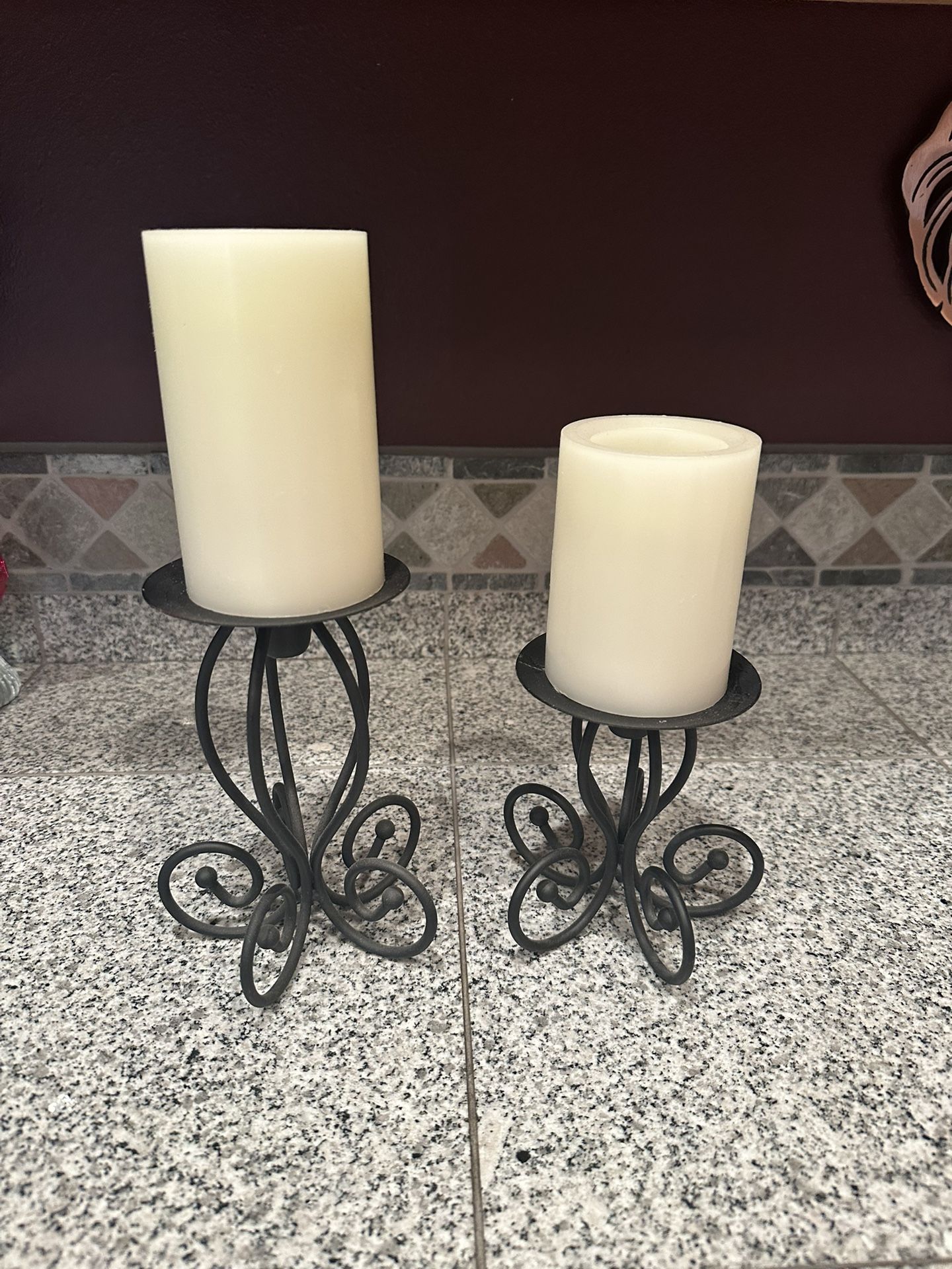 Pair of black metal candlesticks 12” and 9” tall with white battery operated wax feel candles and working batteries!