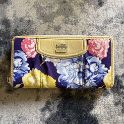 Coach zip-around wallet with navy floral canvas.