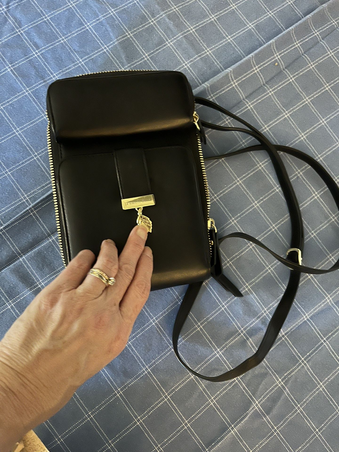 Stylish black leather crossbody bag with gold accents.